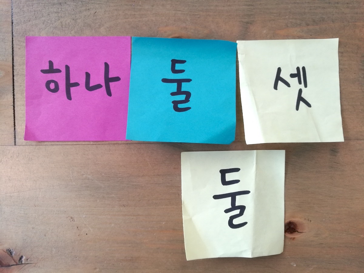 Four sticky notes with the words 'one,' 'two,' 'three,' and 'two' respectively. The 'three' and one of the two 'two' notes are of the same color.